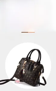 Detail of retro monogram PU leather tote bag with gold cat pendant and tassel charm