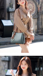 Detail of dark green leather bucket bag with brown strap and metal ring hardware