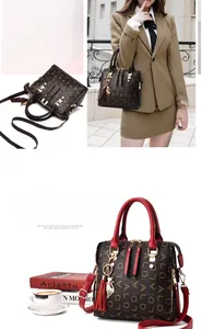 Detail view of monogram tote bag with cat pendant and tassel in coffee brown and red