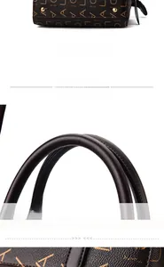 Detail of reinforced arched handles and four gold protective metal studs on handbag base