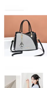 Close-up of contrast patchwork tote with metal ring handles and butterfly pendant charm
