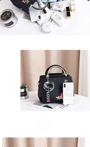 Vue détaillée de l'intérieur spacieux du sac à main noir avec broderies de fleurs