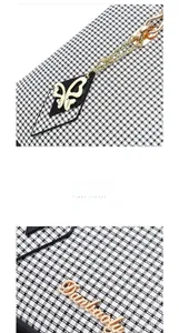 Detailed macro view of black and white houndstooth fabric with gold chain and logo plaque