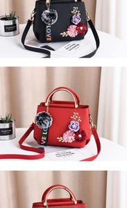 Détail du sac bandoulière en cuir avec broderie florale 3D et pendentif charm love