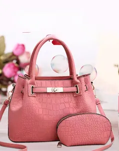 Détail du sac à main rose gaufré crocodile avec fermoir tournant et petit porte-monnaie