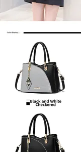 Detail of grid pattern handbag with black faux leather trim and gold butterfly charm