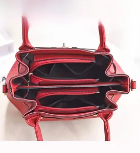 Vue macro de la structure interne du sac à main rouge avec trois compartiments zippés