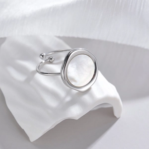 Irregular silver steel ring with round white mother of pearl inlay on artistic plaster