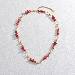 14k gold-plated necklace with irregular red stones and hollow golden beads on white surface