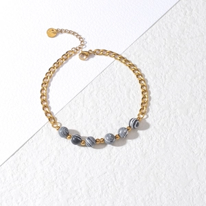 Detail of gold-plated stainless steel Cuban link bracelet with striped marble beads