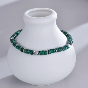 Detail of beaded bracelet with green natural stone beads and silver metal spacers