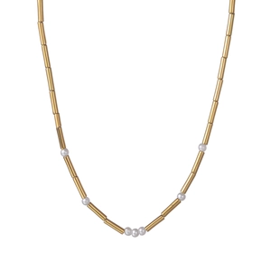 Macro detail of 14K gold plated tube beads and white pearls on a minimalist necklace