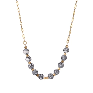 Gold stainless steel necklace with black and white striped beads in a curved layout