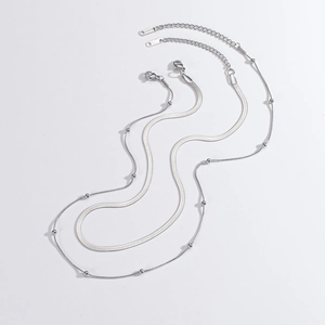 Detail of silver double-layered stainless steel necklace with snake and bead chains