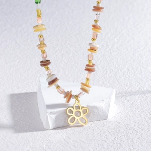 Bohemian colorful beaded flower necklace with a hollow gold floral pendant on white stone