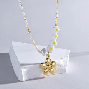 Detailed close-up of colorful beads, white flower accents and gold floral pendant