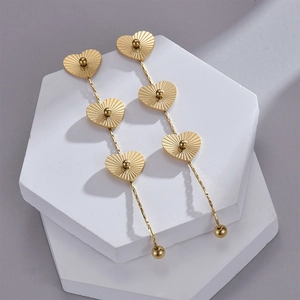 Détail de boucles d'oreilles cœur en acier inoxydable doré 14K sur supports hexagonaux