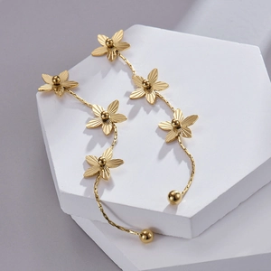 Gros plan de boucles d'oreilles fleurs en acier inoxydable plaqué or 14 carats