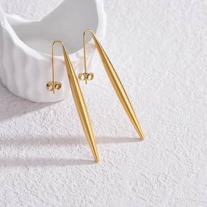 Vue macro de longues boucles d'oreilles cônes dorées avec finition miroir sur céramique