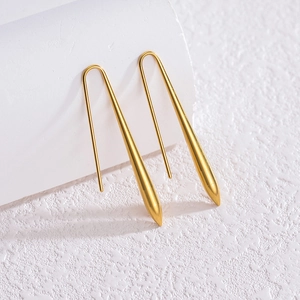 Boucles d'oreilles en or 18 carats en forme de goutte d'eau sur support minimaliste blanc