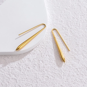 Gros plan de boucles d'oreilles goutte dorées avec finition polie et crochets en U