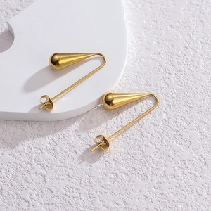 Vue macro de boucles d'oreilles goutte d'or au fini poli miroir épuré