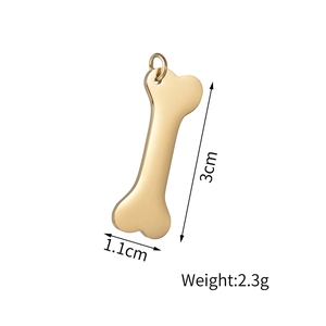 Macro shot of gold bone-shaped pendant with dimensions 3cm by 1.1cm and 2.3g weight