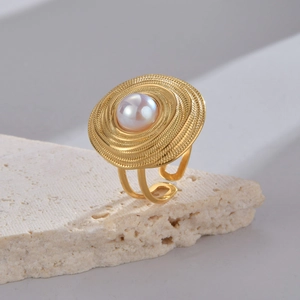 Detailed close-up of a starfish-inspired stainless steel ring on a textured travertine stone