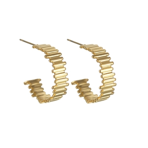 Macro detail of gold C-shaped earrings featuring industrial striped texture and polished finish