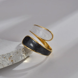 Minimalist gold-tone open ring featuring white marble and black teardrop accents on stone