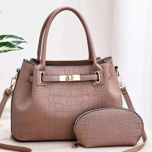 Détail d'un ensemble cabas en cuir à motif crocodile avec chaîne et fermoir doré
