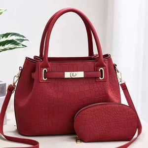 Détail d'un ensemble de sacs rouges en relief crocodile avec quincaillerie dorée chic