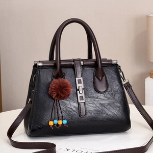 Elegant black faux leather tote bag with brown handles and colorful tassel charm decoration