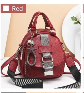 Detailed view of red soft PU leather backpack with star charm and striped strap