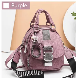 Detail of purple soft leather backpack with litchi texture and metal charms decoration