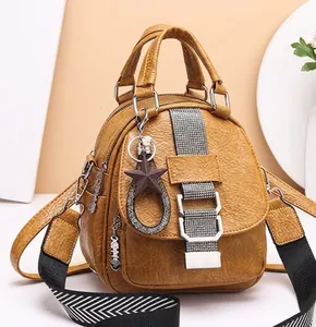 Detail of yellow soft leather backpack with stylish geometric strap and star pendant