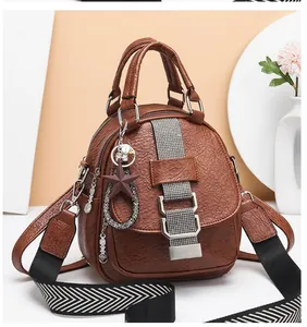 Detail of earth yellow pebbled leather backpack with sparkling silver strap and star charm