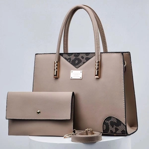 Detailed view of taupe tote bag set with black lace patch and metallic gold hardware