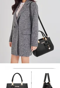 Detail of black pebbled faux leather handbag with golden bow accent and floral charm