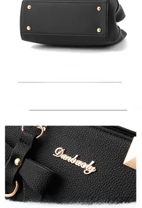 Detail of black pebbled leather handbag featuring gold protective feet and brand logo hardware