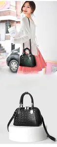 Detailansicht der schwarzen Handtasche mit Krokodilmuster und silbernen Beschlägen