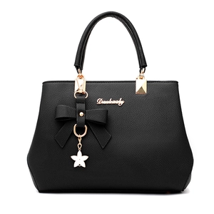 Elegant black pebbled leather handbag with gold accents and a floral charm for women