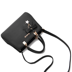 Elegant black lychee grain PU leather handbag with gold hardware and floral charm