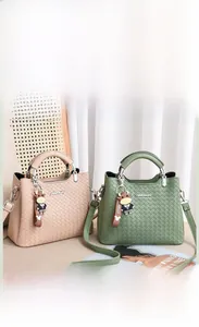 Detailansicht der gewebten Handtaschen in Matcha-Grün und Beige mit süßen Anhängern