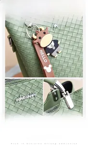 Detailansicht der grünen gewebten Ledertasche mit Silberlogo und dekorativem Anhänger