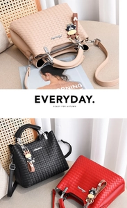 Detail von gewebten Handtaschen in Beige, Schwarz und Rot mit süßen Anhängern
