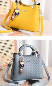 Detail von gewebten Handtaschen in Gelb und Grau mit Bullenanhänger-Elementen
