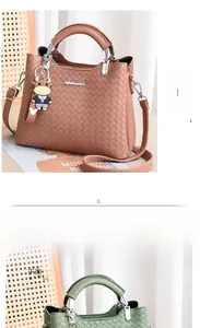 Detailansicht der gewebten Handtasche mit Metallgriff und niedlichem Anhänger