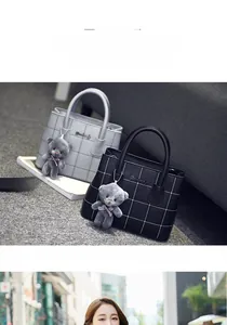 Dettaglio della borsa tote a scacchi con ciondolo a forma di orso in grigio e nero