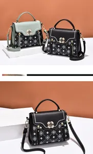 Detail of floral print small square bags with elegant gold flower buckles and top handles